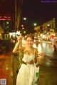 A woman in a white dress holding a bunch of flowers.