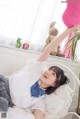 A woman laying on a bed holding a pink stuffed animal.