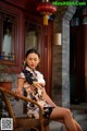 A woman sitting on a chair in front of a building.