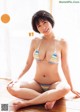 A woman in a bikini sitting on the floor.