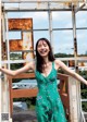 A woman in a green dress standing on a balcony.