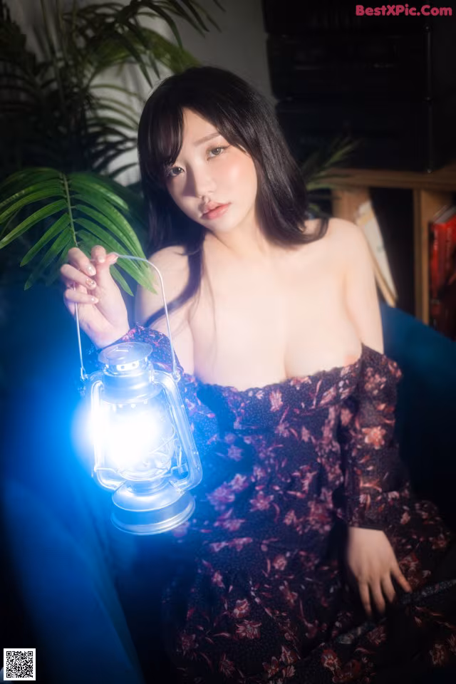 A woman sitting on a couch holding a lantern.