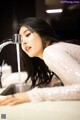 A woman is washing her face under a faucet.