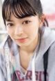 A young woman in a gray sweatshirt is posing for a picture.