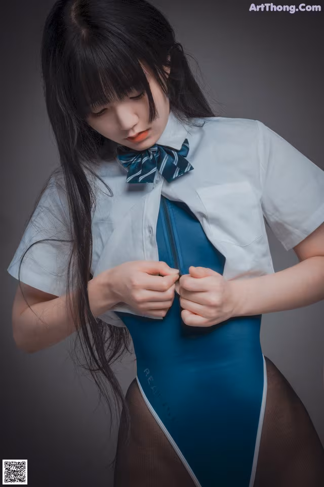 A woman in a blue bodysuit with a bow tie.